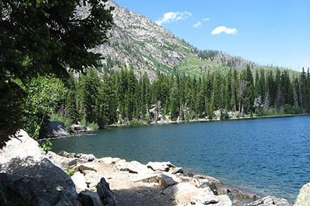 trail by the lake with mountains rising to the west